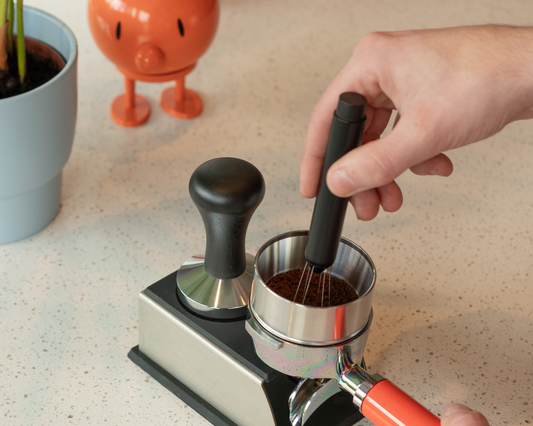 Iemand gaat met een WDT tool door de koffie heen